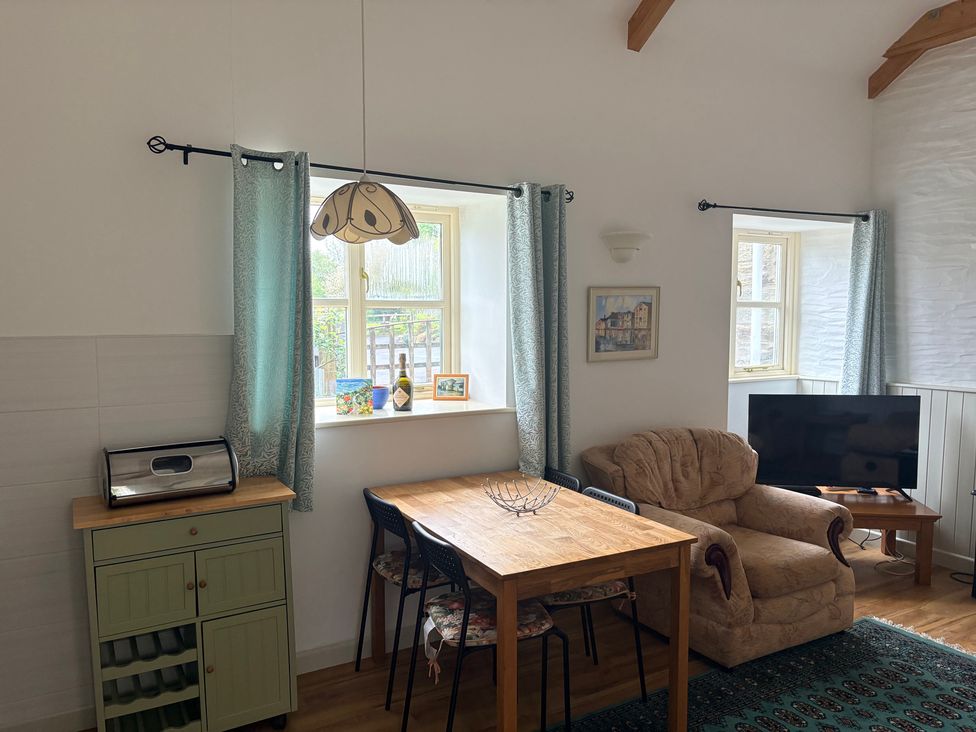 A living room with a sofa and table at Sunlight Cottage St Erme near Truro
