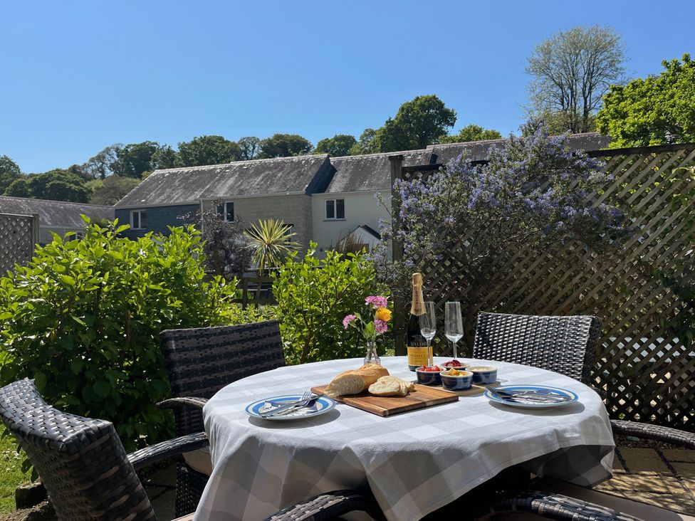 An outdoor dining area with a table set for a meal at Breeze Cottage in Falmouth