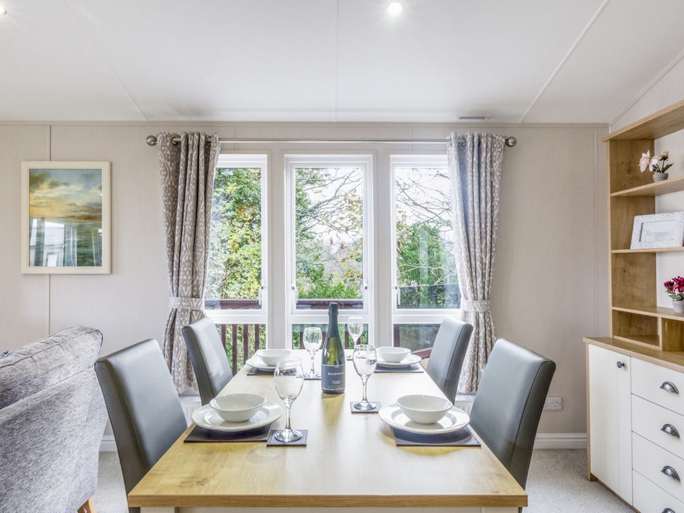 A dining room with a table set for a meal at Lodge 58 at Riviera Bay Coastal Retreat Brixham