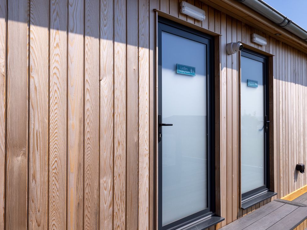 Two doors with signs near wooden wall at Lodge 63 at Riviera Bay Coastal Retreat Brixham