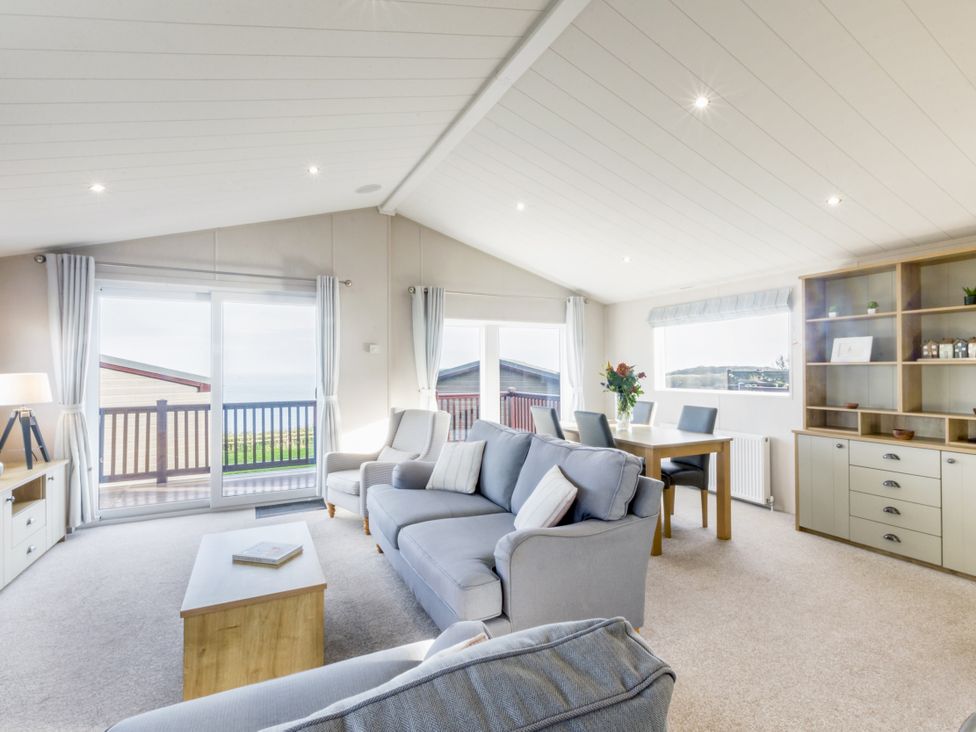 A living room with a sofa and dining table at Lodge 63 at Riviera Bay Coastal Retreat Brixham