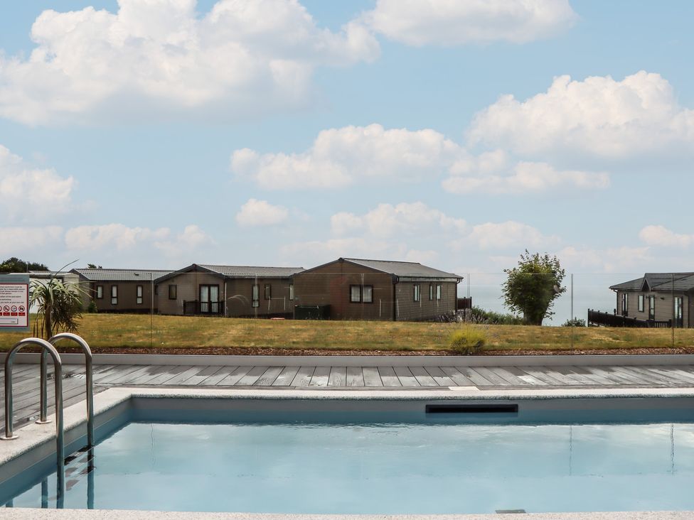An outdoor area with a swimming pool and buildings at Lodge 69 at Riviera Bay Coastal Retreat Brixham