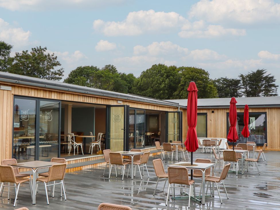 An outdoor dining area with tables and umbrellas at Lodge 69 at Riviera Bay Coastal Retreat Brixham