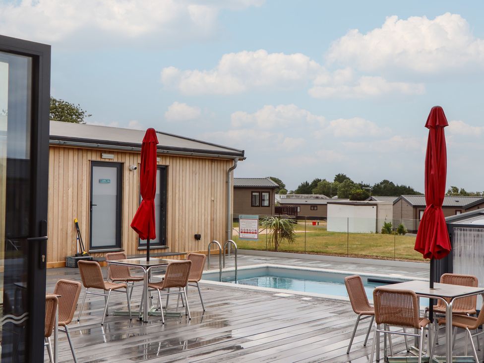 An outdoor area with pool and seating at Lodge 69 at Riviera Bay Coastal Retreat Brixham