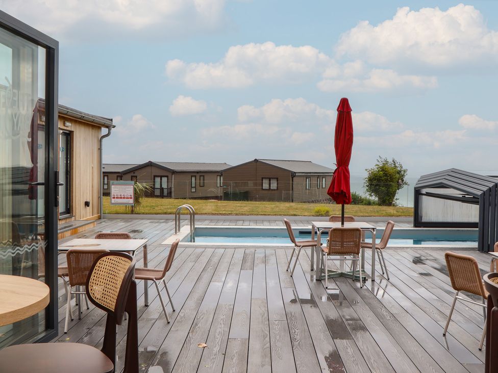 An outdoor area with a pool and seating at Lodge 69 at Riviera Bay Coastal Retreat Brixham