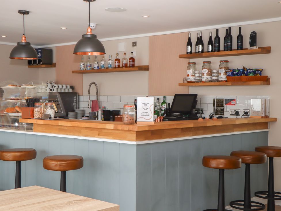 A café bar area with stools and shelves at Lodge 69 at Riviera Bay Coastal Retreat Brixham