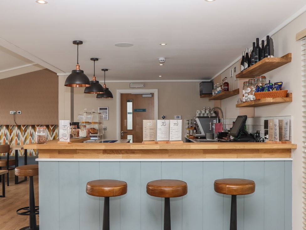 A bar with stools and a coffee machine at Lodge 69 at Riviera Bay Coastal Retreat Brixham