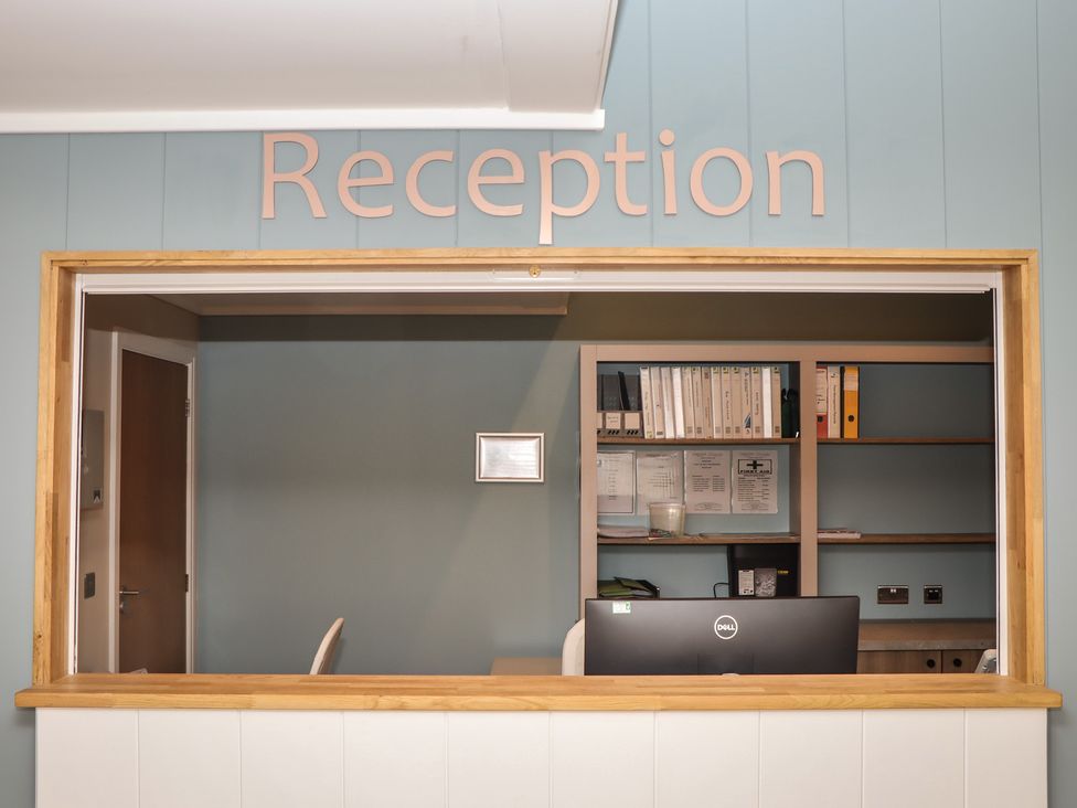 A reception area with a desk and shelves at Lodge 69 at Riviera Bay Coastal Retreat Brixham