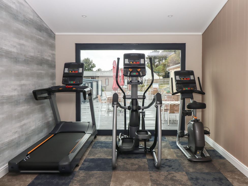 A gym with treadmill elliptical and exercise bike at Lodge 69 at Riviera Bay Coastal Retreat Brixham