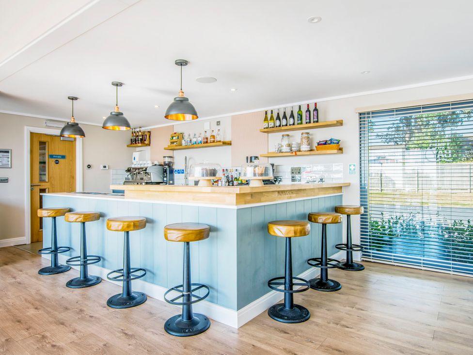 A bar area with stools and shelves at Lodge 68 at Riviera Bay Coastal Retreat Brixham