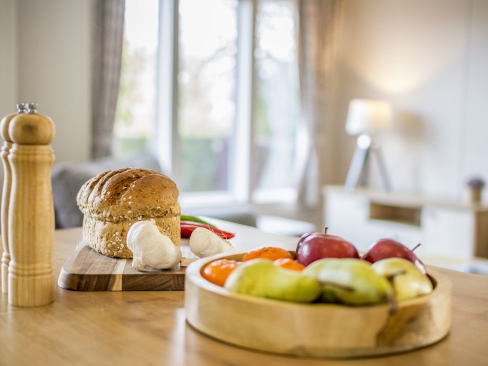 A kitchen with bread and fruits on a table at Lodge 71 at Riviera Bay Coastal Retreat Brixham