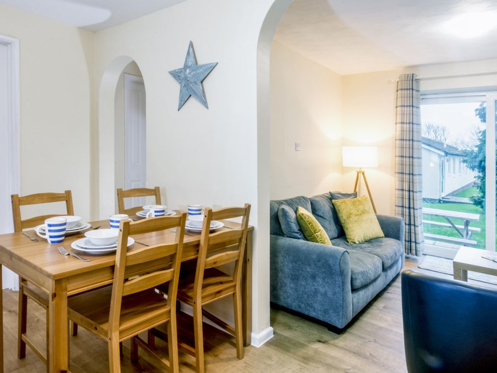 A dining area with a table and chairs at Chalet 7 at Landscove Holiday Park Brixham
