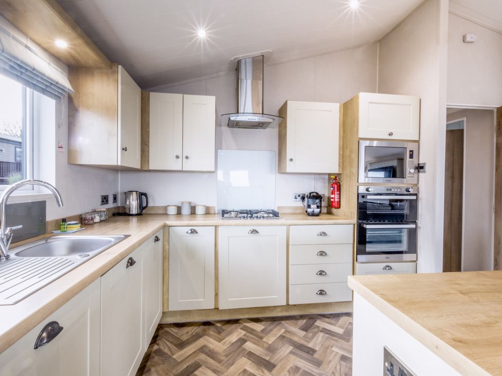 A kitchen with cabinets and appliances at Lodge 64 at Riviera Bay Coastal Retreat Brixham