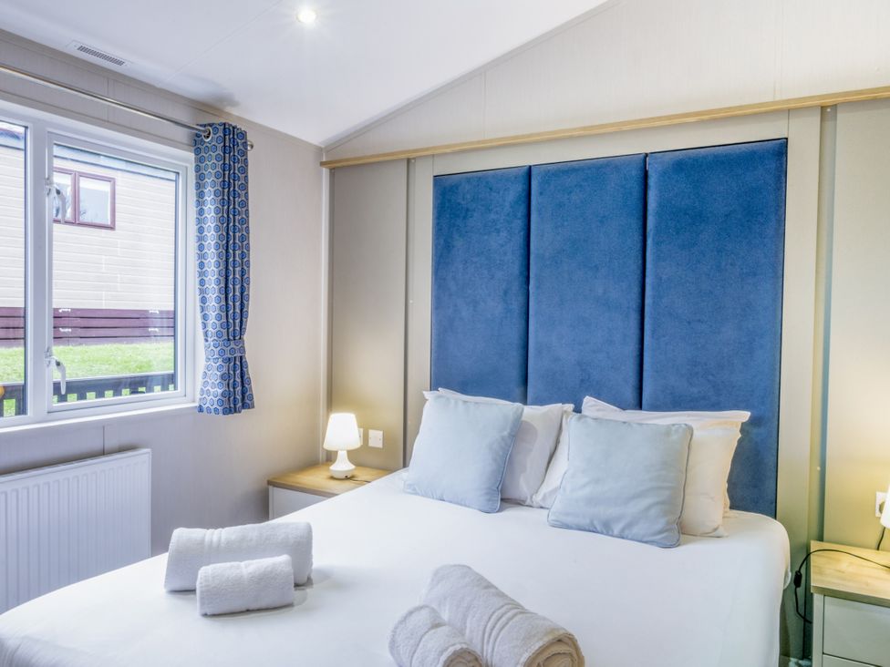 A bedroom with a bed and bedside table at Lodge 64 at Riviera Bay Coastal Retreat in Brixham