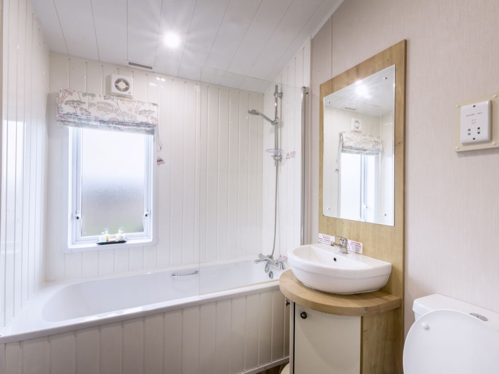 A bathroom with a bathtub, sink, and shower at Lodge 72 at Riviera Bay Coastal Retreat Brixham
