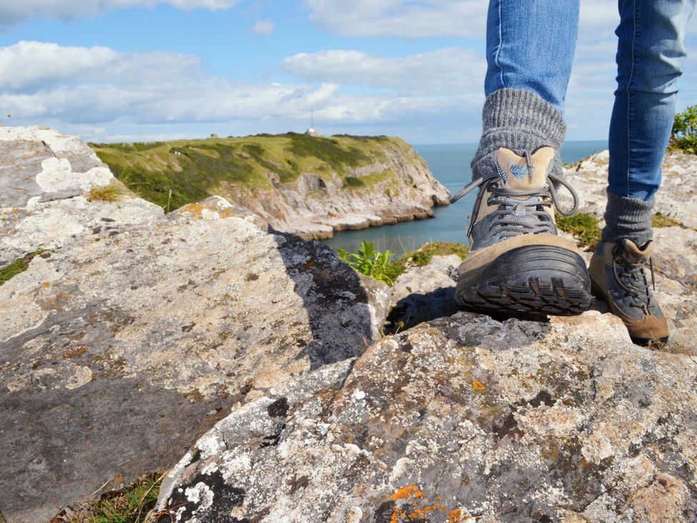 A hiker's foot on a rock near the sea at Chalet 11 at Landscove Holiday Park Brixham