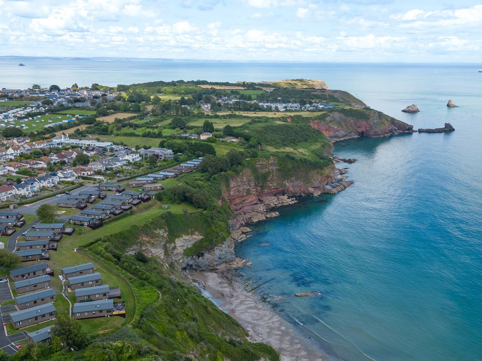 An aerial view of a coastline showing a holiday park near the sea at Chalet 15 at Landscove Holiday Park, Brixham