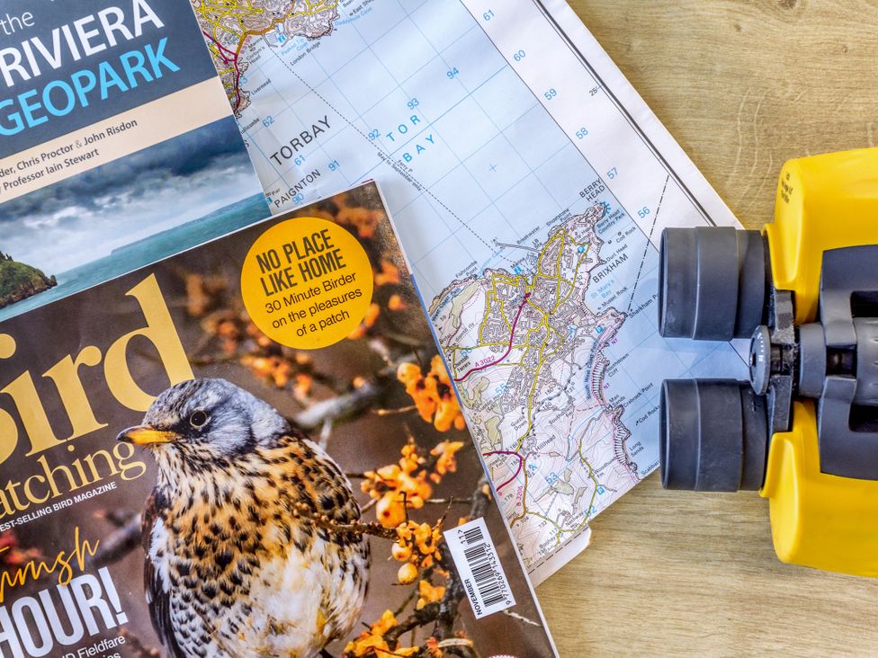 A map, bird watching magazine, and binoculars at Chalet 38 at Landscove Holiday Park Brixham