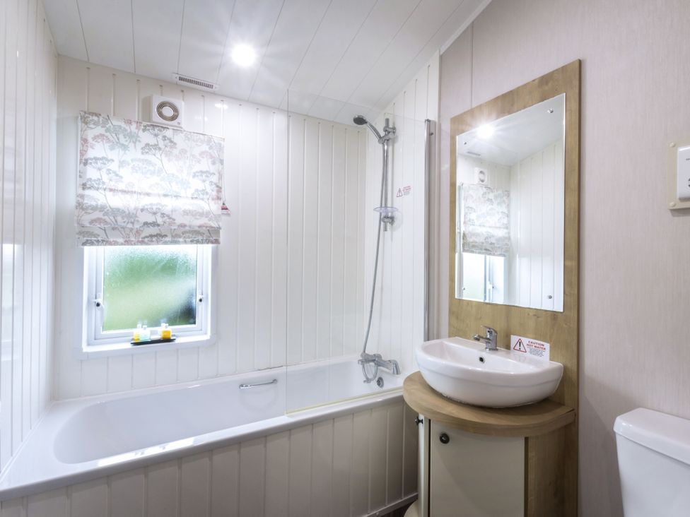 A bathroom with shower and sink at Lodge 9 at Landscove Holiday Park Brixham