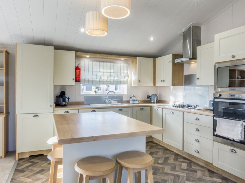 A kitchen with an island and appliances at Lodge 11 at Landscove Holiday Park, Brixham