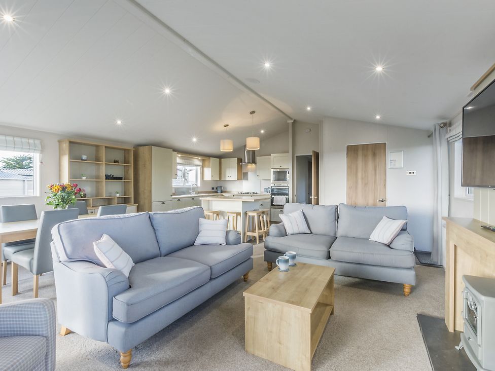 A living room with sofas and a dining area at Lodge 11 at Landscove Holiday Park in Brixham