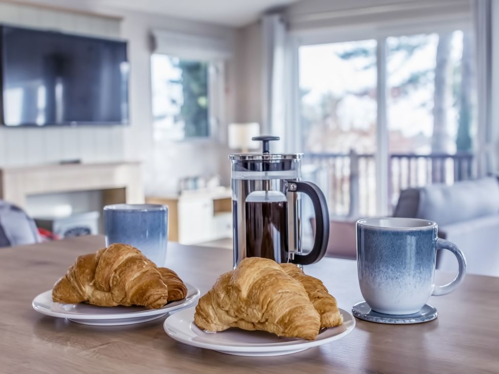 A table with croissants and coffee maker at Lodge 11 at Landscove Holiday Park Brixham