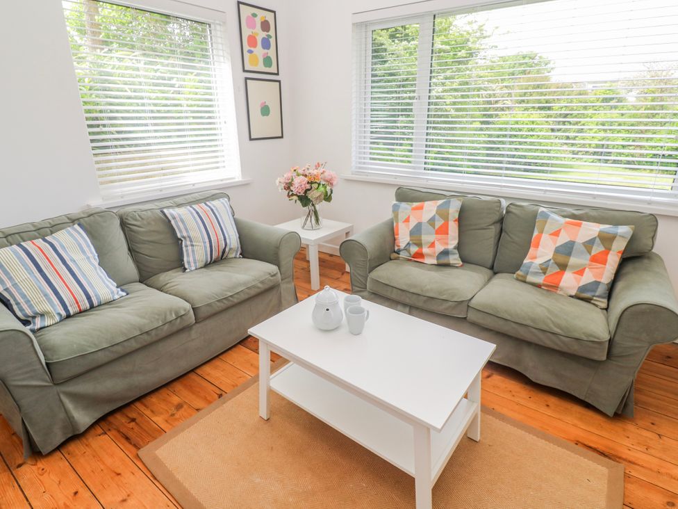 A living room with sofas, a coffee table and a vase of flowers at Bod A Quinte, Carbis Bay
