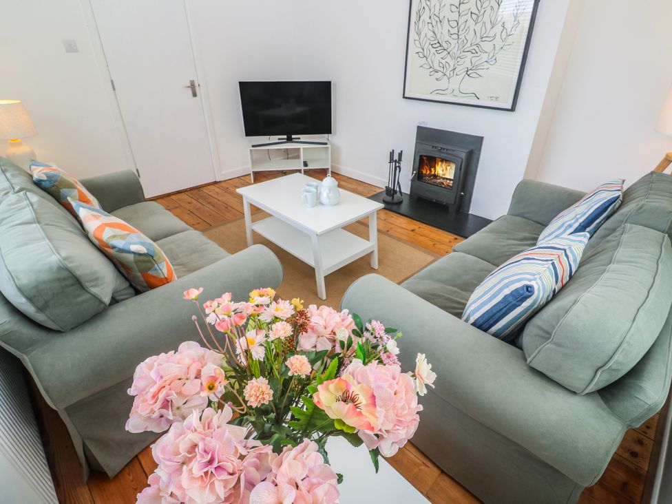 A living room with a fireplace and a TV at Bod A Quinte in Carbis Bay