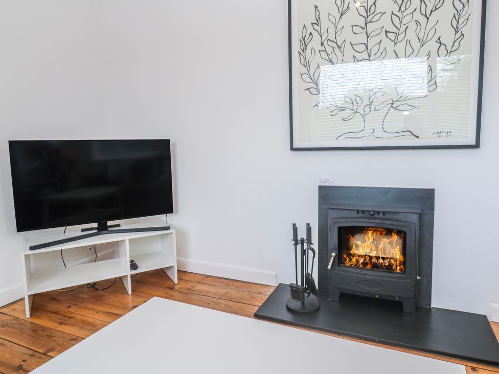 A living room with a fireplace and television at Bod A Quinte in Carbis Bay