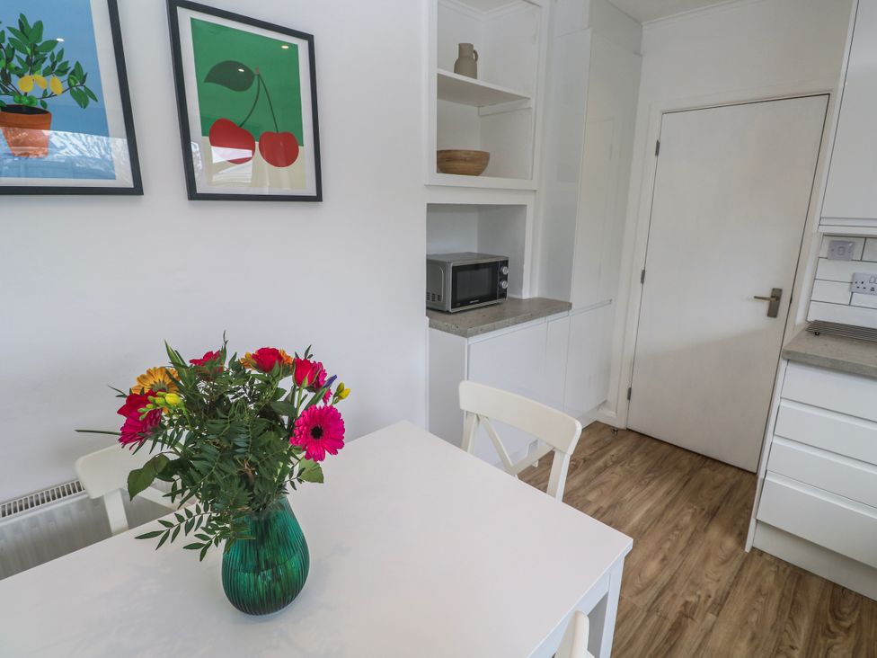 A kitchen with a table and flowers at Bod A Quinte in Carbis Bay