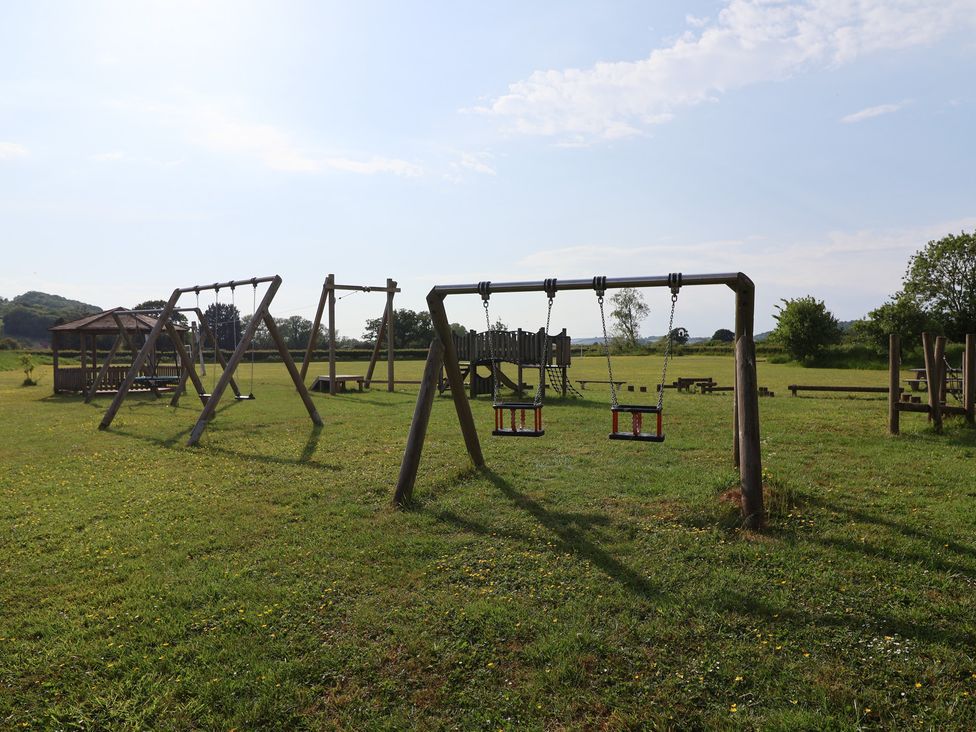 An outdoor playground with swings and a playground structure at Metcalfe House in Compton Dundon