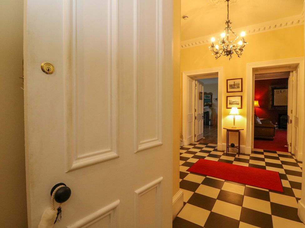 A hallway with a door and a chandelier at Rudha Na Craig in Inveraray
