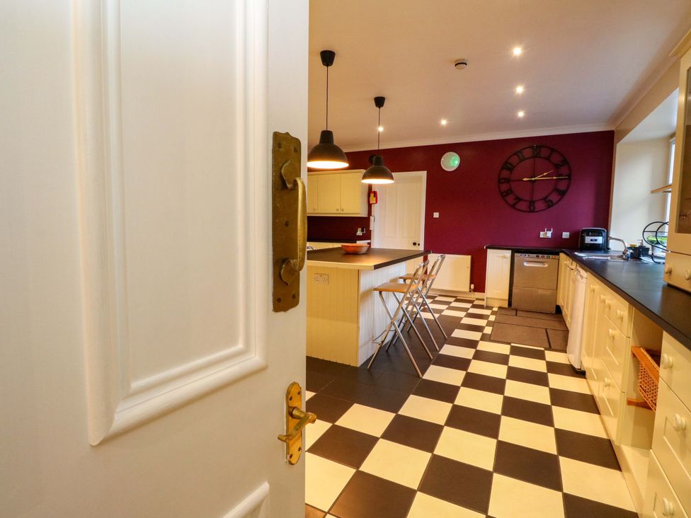 A kitchen with a door opening to a view of the kitchen island at Rudha Na Craig in Inveraray