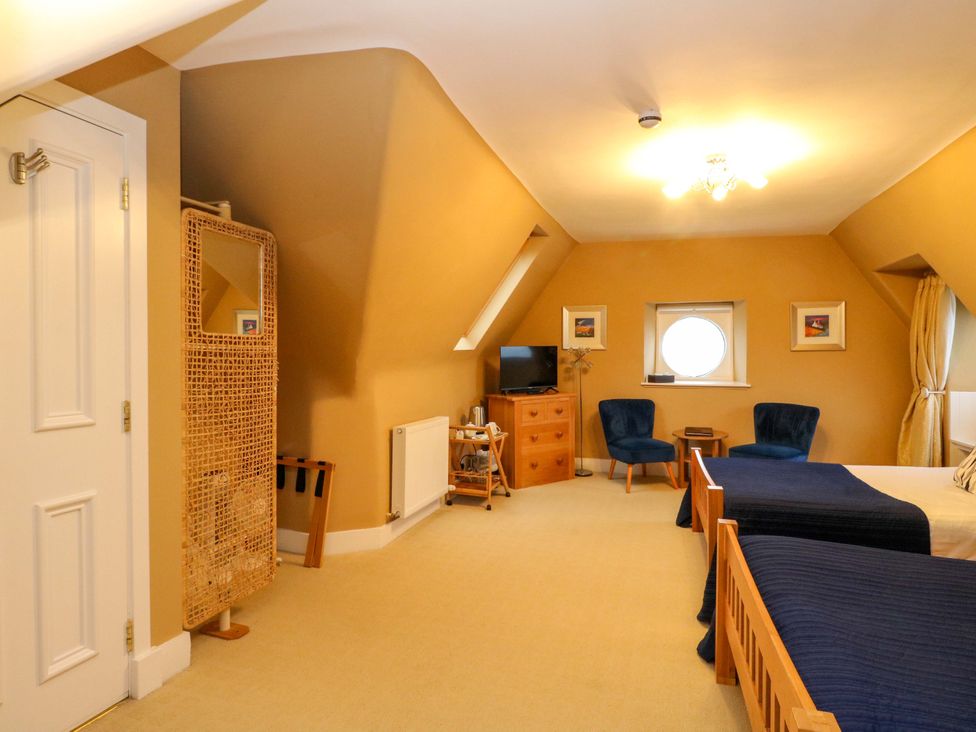 A bedroom with beds and a television at Rudha Na Craig in Inveraray