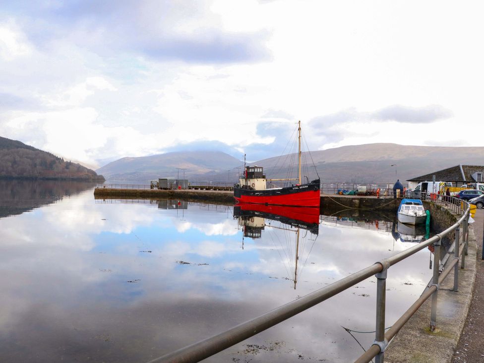 A harbor with boats and mountains in the background at Rudha Na Craig Inveraray