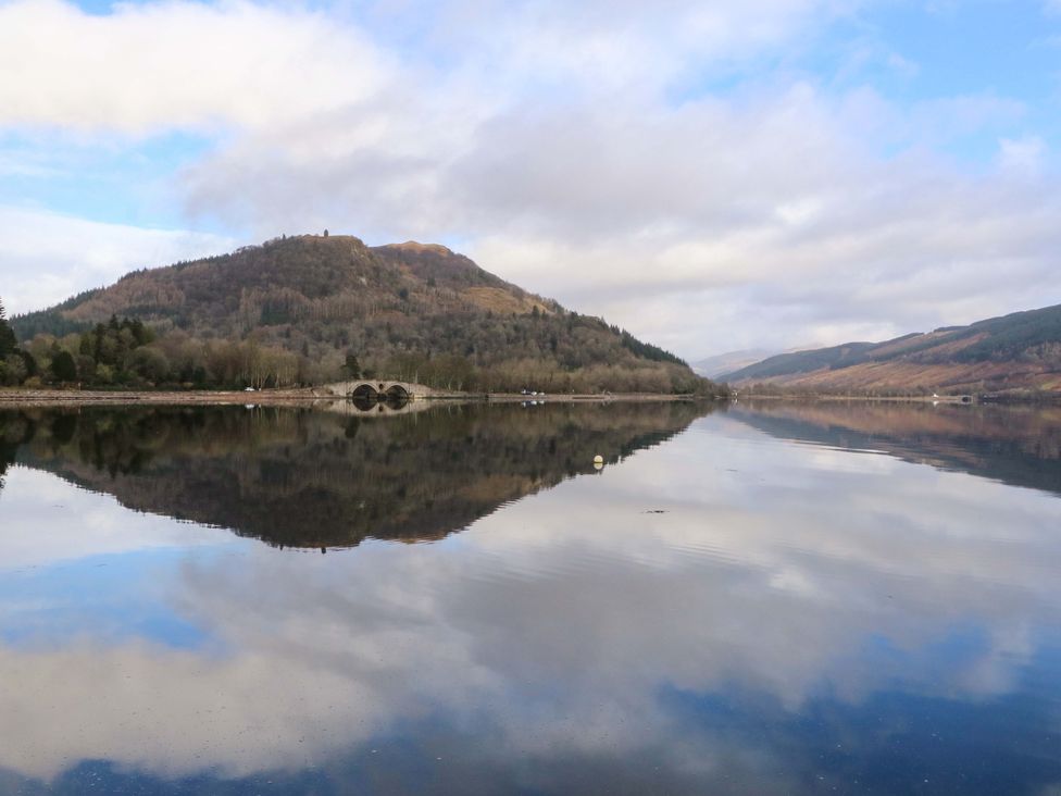 A landscape view of a lake with mountains and trees at Rudha Na Craig Inveraray