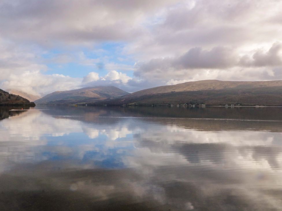 A view of mountains and water with reflective surface at Rudha Na Craig Inveraray