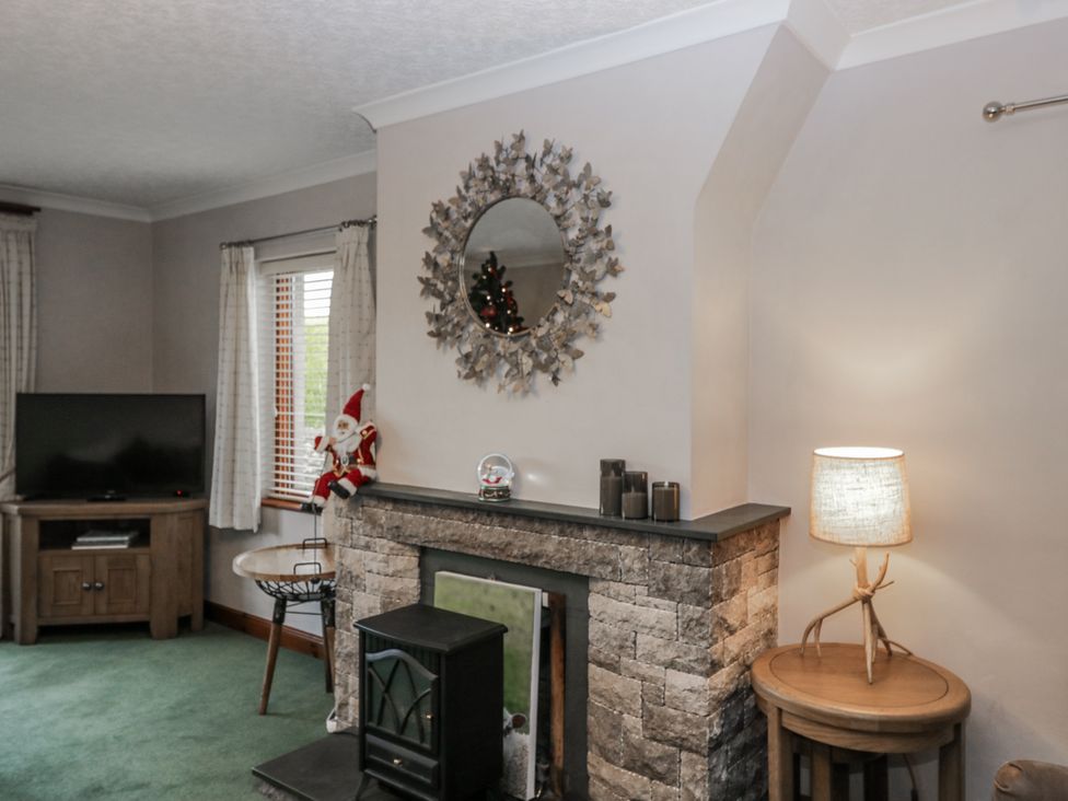 A living room with a television and fireplace at 1 Gilpin House Levens