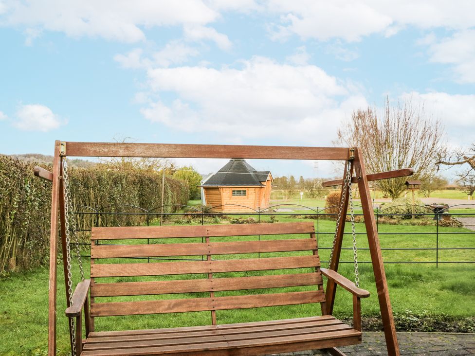 A swing in a garden with a shed in the background at 1 Gilpin House Levens