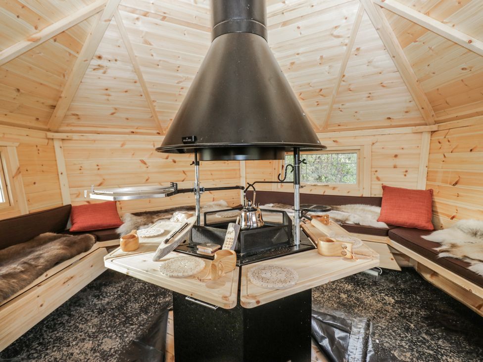A gathering space with wooden walls and a center heating device at 1 Gilpin House in Levens