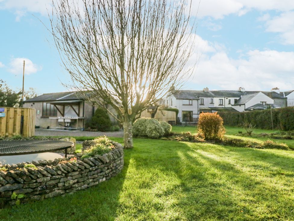 A garden with a tree and a house in the background at 1 Gilpin House Levens