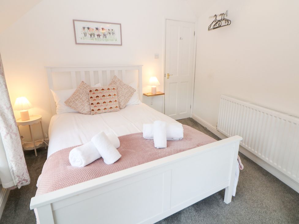 A bedroom with a double bed and side table at Roseville in Cromford