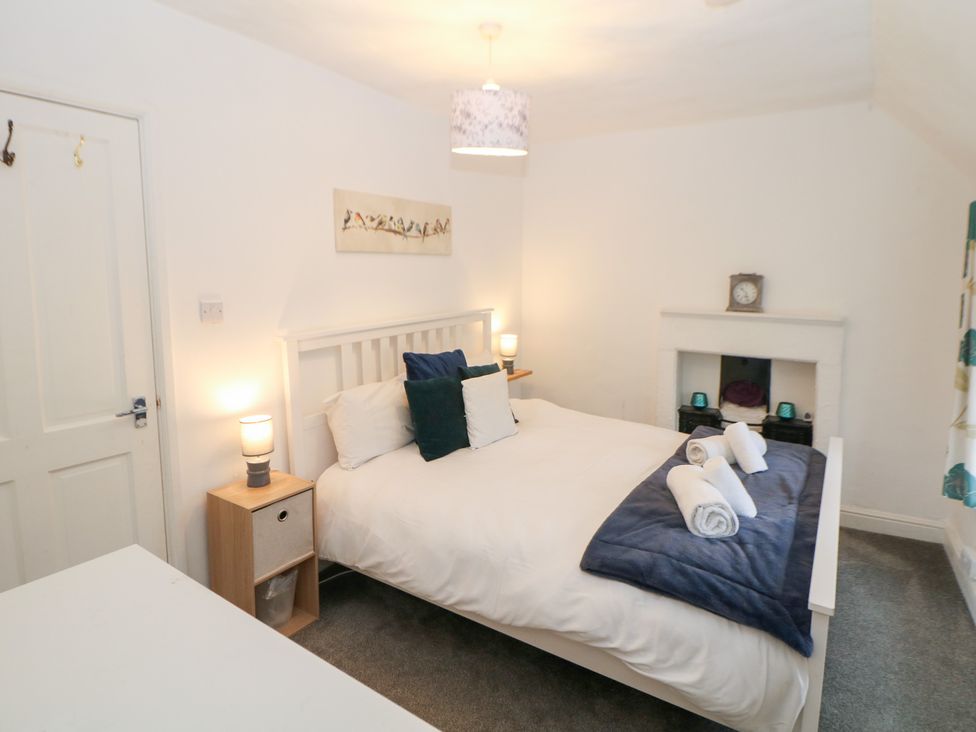 A bedroom with a bed and decorative items at Roseville in Cromford