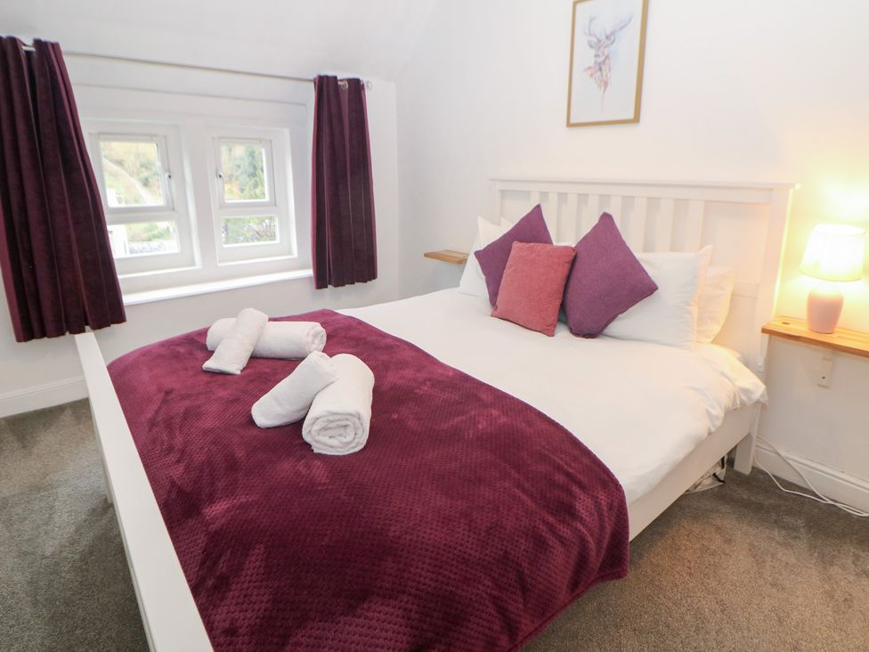 A bedroom with a bed and curtains at Roseville in Cromford