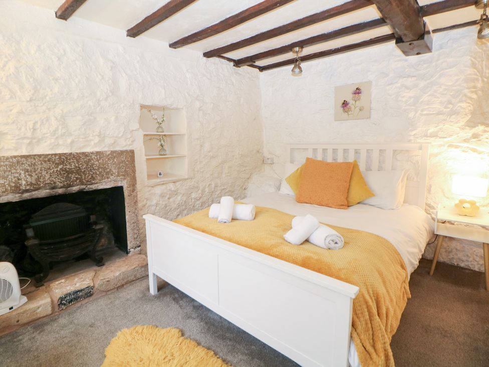 A bedroom with a bed and fireplace at Roseville in Cromford
