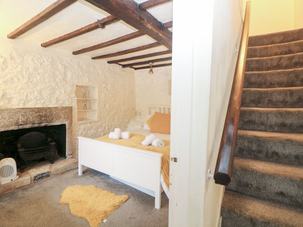 A bedroom with a bed and fireplace at Roseville in Cromford