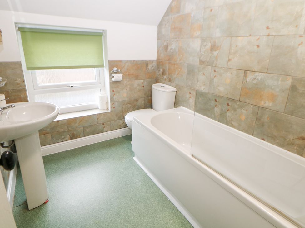A bathroom with a bathtub, toilet, and sink at Roseville in Cromford