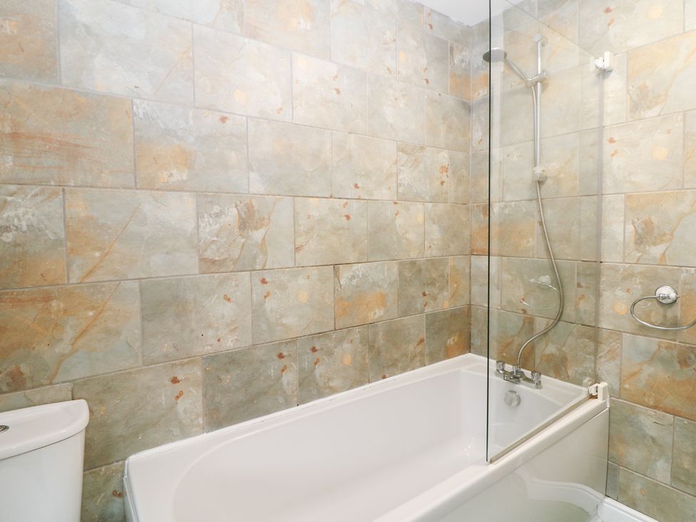 A bathroom with a bathtub and shower at Roseville in Cromford