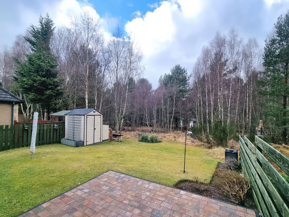 A garden with a shed and grass area at 6 Carn Dearg in Aviemore