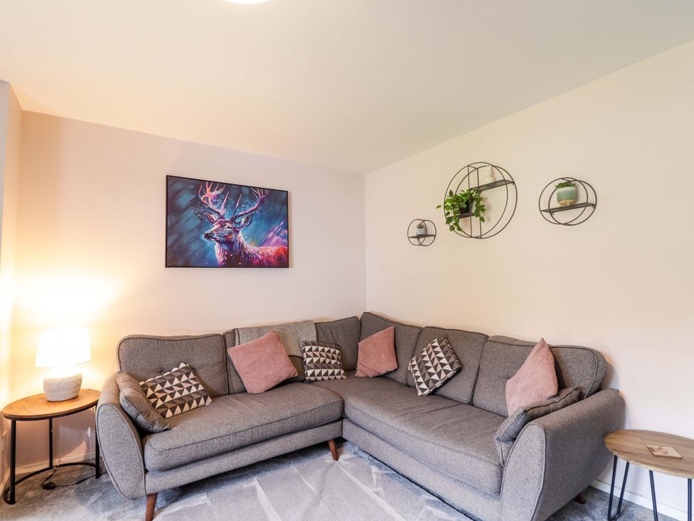 A living room with a sofa and wall art at 6 Carn Dearg in Aviemore
